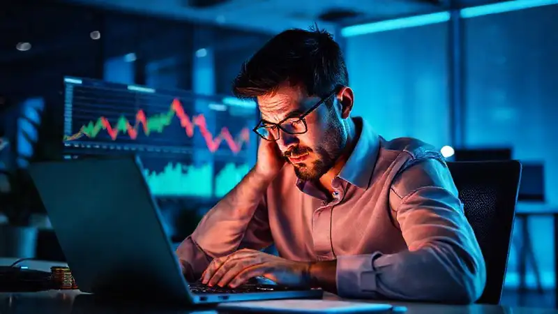 Un hombre estresado observa mercados digitales